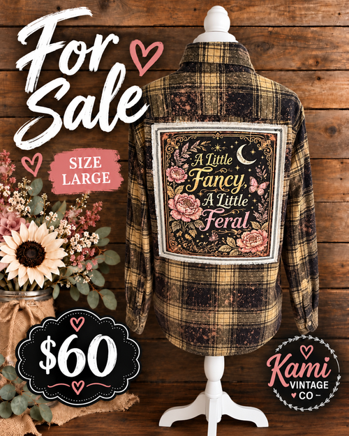 Size Large black and tan plaid flannel with A Little Fancy, A Little Feral floral, butterfly, and crescent moon back panel.