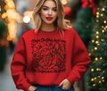 Red crewneck sweatshirt with black Grinch Christmas graphic, gift bow and snowflakes
