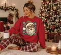 Red Gildan Christmas crewneck sweatshirt featuring Santa with leopard-print hat and glasses, snowflakes and stars